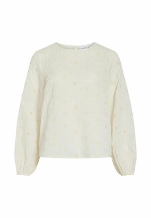 Blouse crème à manches longues avec broderie délicate en œillets floraux, col rond et poignets élastiqués, présentée sur fond blanc.