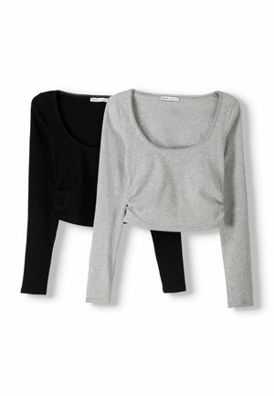 Hauts à manches longues cropped en noir et gris. Tissu à côtes doux, encolure dégagée, design ajusté avec détails de ruché sur les côtés.