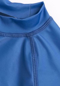 Blå sporttop med slät, glänsande tyg och hög krage. Synliga sömmar och en figurnära design.