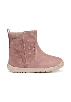 Stivaletti alla caviglia in suede rosa con motivi a cuore, finitura texture e suola in gomma beige. Presenta un loop per facilitare l'indossamento. Marchio Geox visibile.