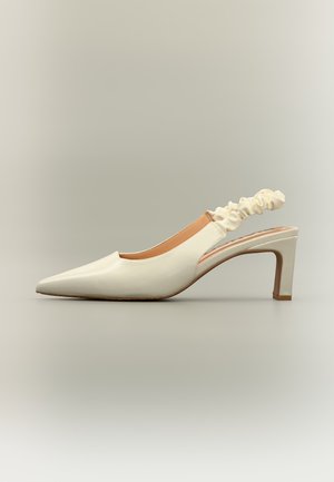 Chaussure à talon haut slingback pour femme de couleur crème avec bout pointu et bride élastique froncée sur fond neutre.