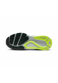 Suela de zapato con una sección de goma texturizada negra, entresuela gris y acentos vibrantes en verde neón en un diseño ondulado. Múltiples patrones de agarre visibles.