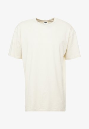 Kortärmad t-shirt med rundad hals i ljus krämfärgad nyans. Tillverkad av mjukt bomullsmaterial med en avslappnad passform och minimala sömmar.