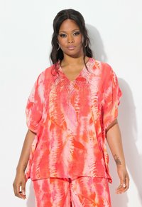 Top tie-dye di un vivace rosa e arancione con scollo a V e maniche corte, decorato con perline lungo il collo per un tocco di dettaglio in più.
