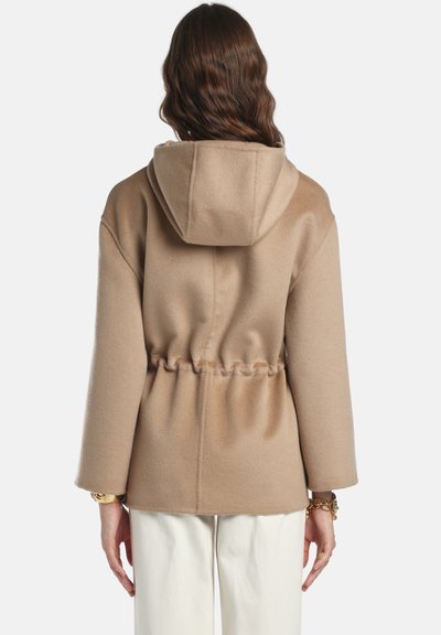 Palton bej cu glugă, talie strânsă, material texturat, mâneci largi și finisaj neted. Fără închideri sau modele vizibile.