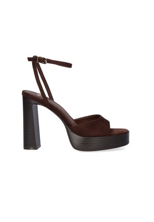 Sandalia de plataforma de ante marrón oscuro con tacón grueso de bloque y tira delgada en el tobillo con hebilla dorada sobre fondo blanco.