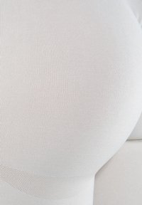 Shapewear beige con texture a costine, design senza cuciture e bordi lisci. Il tessuto è elasticizzato e aderente, offrendo una silhouette snella.