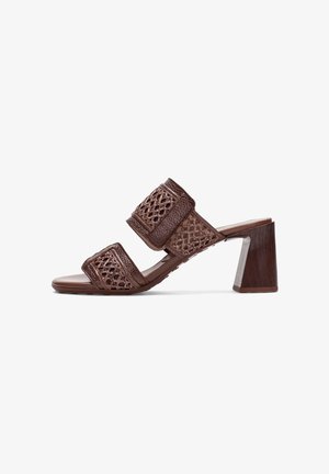 Bruine leren sandaal met hak, met twee brede gevlochten bandjes en een blokhak, zijaanzicht op een witte achtergrond.