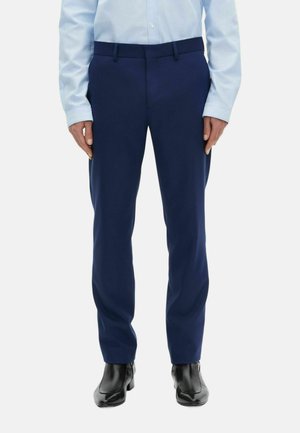 Marineblauwe op maat gemaakte broek met een gladde textuur, voorzien van een standaard tailleband en een voornaad, gedragen met zwarte nette schoenen.