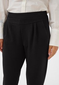 Cream CRANNIKA - Trousers - pitch black/black - Zalando