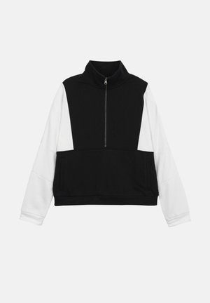 Sort-hvid langærmet pullover med en halvlukket lynlås foran og høj krave, med sort krop og hvide ærmer.