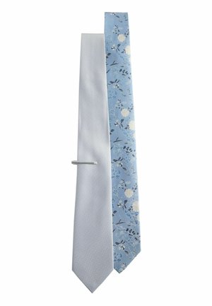 Two men's neckties side by side: one light blue with a textured pattern, the other light blue with a floral print, with a silver tie clip.