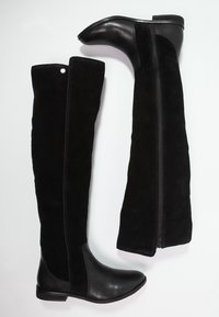 Stivali neri sopra il ginocchio realizzati con una combinazione di pelle liscia e morbido suede, con punta affusolata, zip laterale e tacco piatto.