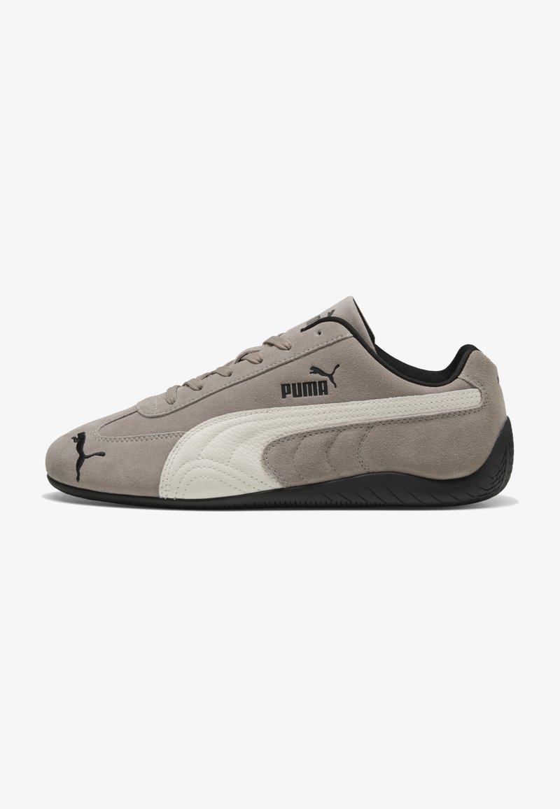 Baskets Puma en daim gris avec bande latérale en cuir blanc, semelle noire, logos Puma noirs sur le côté, la languette et l'avant, coupe basse.