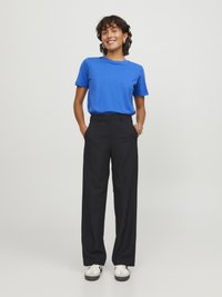 Blauw T-shirt met korte mouwen, gecombineerd met zwarte high-waisted wijde broek en witte sneakers. Eenvoudige, relaxte pasvorm overal.