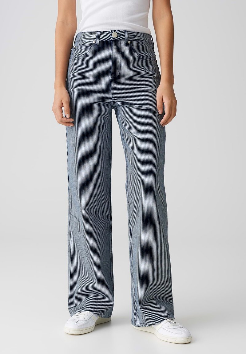 Jean taille haute, coupe large, à rayures verticales bleu et blanc, avec fermeture à bouton, cinq poches et une texture en denim douce.