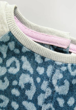 Pull bleu et gris à motifs avec un design léopard texturé, présentant un col strié gris et des accents roses au niveau du col.