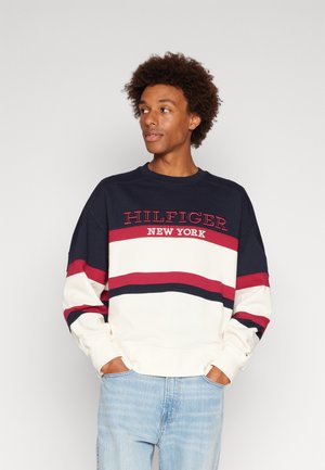 Felpa blu navy e crema con strisce rosse e logo "HILFIGER NEW YORK". Presenta un collo a giro e una vestibilità comoda, realizzata in tessuto morbido.