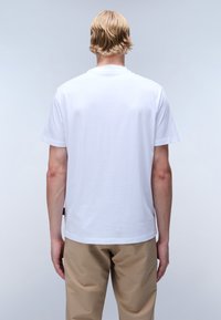 Bílý bavlněný tričko s crew neck výstřihem a krátkými rukávy, hladká struktura a rovný lem, pohled z zad.