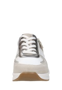 White and beige sneaker with white laces, metallic gray tongue panel, side zipper, and brown rubber sole, shown from front view.