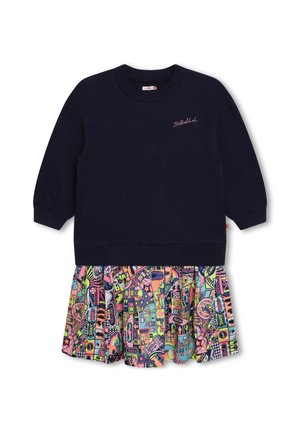 Mørkeblå sweatshirt med lange ærmer og lyserød "Billieblush"-tekst samt et farverigt plisseret skørt med tegneseriemønster, fastgjort ved kanten.