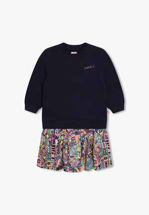 Granatowa bluza z długim rękawem z różowym napisem „Billieblush” oraz kolorową plisowaną spódniczką w kreskówkowy wzór przyszytą u dołu.