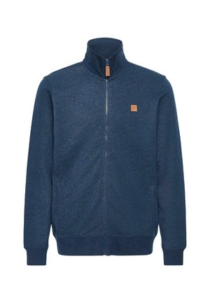 Granatowa kurtka zapinana na zamek wykonana z miękkiego materiału, z wysokim kołnierzem, dwiema bocznymi kieszeniami oraz małą beżową naszywką z logo na piersi.