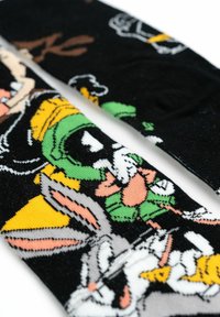 Calze nere con personaggi colorati, tra cui Bugs Bunny e Marvin il Marziano, caratterizzate da un morbido motivo a maglia strutturata.
