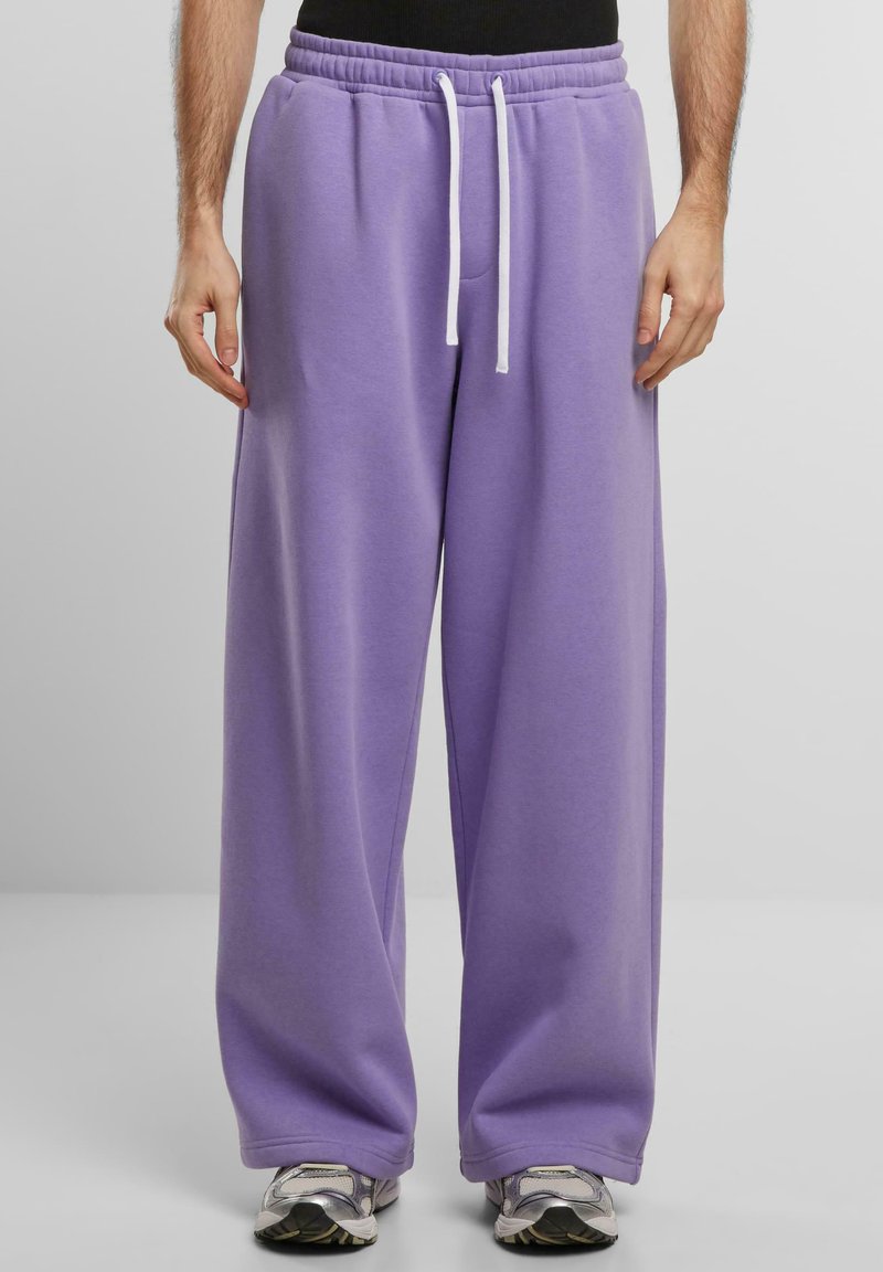 Fioletowe dresy o luźnym kroju, z elastycznym pasem i białym sznurkiem. Miękka tekstura materiału z bocznymi kieszeniami.