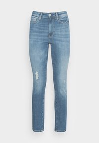 Jeans de denim azul claro con corte slim, que presentan áreas desgastadas en las rodillas, un desvanecimiento sutil y bolsillos delanteros y traseros estándar.