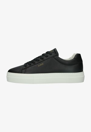 Baskets en cuir noir avec une semelle plateforme blanche. Les caractéristiques comprennent des lacets ronds, une texture lisse et un minimum de branding en or.