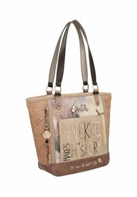 Beige-braune Tragetasche mit doppelten Griffen, dekorativen Aufnähern und Schlüsselanhänger, mit dem Text: "Anekke macht Geschichte" und "Du musst das Leben erfinden."