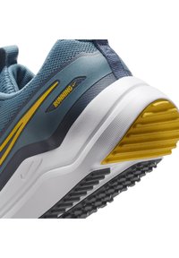 Blue running shoe featuring a mesh upper with yellow and dark blue accents. Treaded rubber sole with a prominent yellow heel section.