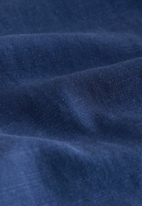 Meresinine kangas, sileda tekstuuri ja peene koega, millel on õrnad voldid ning peened valguse ja varju variatsioonid.