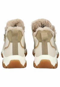 Beige faux leren schoenen met een fluffy kraag, elastische zijpanelen en een robuuste witte zool met bruine accenten.
