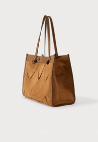 Καφέ τσάντα χειρός από σουέτ με γεωμετρικό μοτίβο, δύο δερμάτινα χερούλια και δομημένο σχήμα. Διαθέτει λείες και ανάγλυφες επιφάνειες.