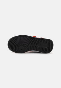 Black rubber sole with a patterned tread, featuring red and white accents and a visible logo. Textured material adds grip.
