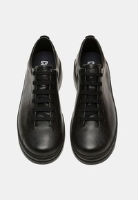 Black leather sneakers with a smooth texture, round toe, and flat rubber sole. Features six eyelets with black laces and a branded insole.