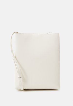 Bolso bandolera rectangular de cuero color crema con una correa ajustable y un sutil logo de Calvin Klein en el frente.