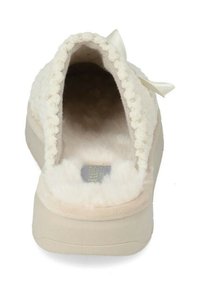 Pantofole morbide color crema con un interno e un esterno testurizzati e pelosi. Presentano un motivo decorativo con fiocchetto e pompon lungo l'apertura.
