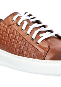 Brązowe skórzane sneakersy z plecioną fakturą, białymi sznurowadłami, złotymi oczkami i białą gumową podeszwą o fakturowanym wykończeniu.