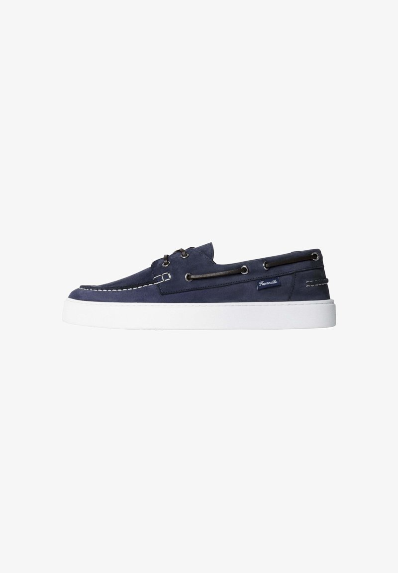 Marineblaue Bootsschuh aus Wildleder mit weißer Gummisohle, schwarzen Leder Schnürsenkeln, die durch silberne Ösen geführt sind, und weißen Steppnähten.