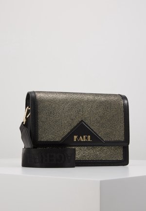 Rechthoekige zwarte en gouden crossbodytas met textuur en het "KARL" logo, zwarte verstelbare riem en gouden hardware, geplaatst op een witte ondergrond.