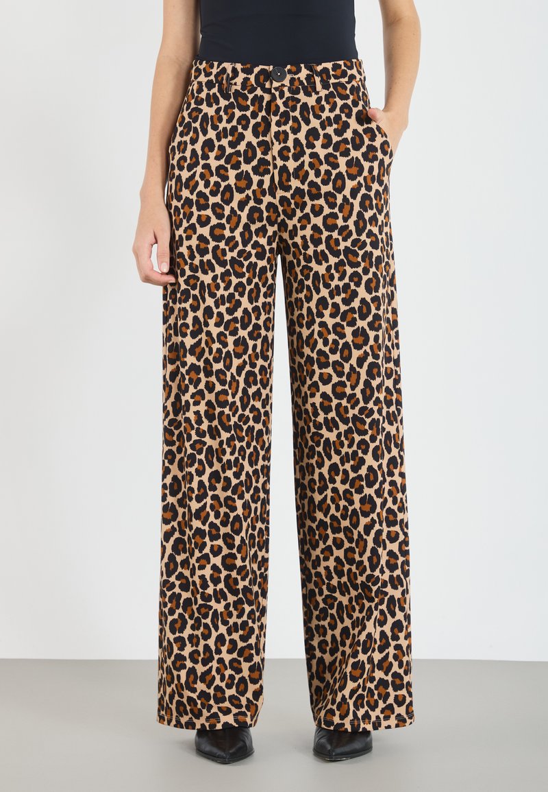 Hlače širokog kroja s leopard uzorkom, izrađene od mekog i gladak materijala, s visokim strukom i bočnim džepovima. Boje uključuju bež, crnu i narančastu.
