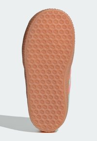 Gumová podrážka tenisky s hexagonálním vzorem v broskvové barvě. Zakřivený okraj s detailní texturou pro lepší přilnavost a trakci.