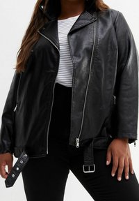 Czarna skórzana kurtka motocyklowa z wysokim kołnierzem, srebrnymi suwakami i regulowanymi paskami z klamrami. Gładka tekstura i oversize'owy krój.