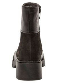 Zwarte leren enkelboot met een gladde afwerking, licht afgeronde neus en een lage blokhak. Voorzien van een zijrits en minimale stikdetails.