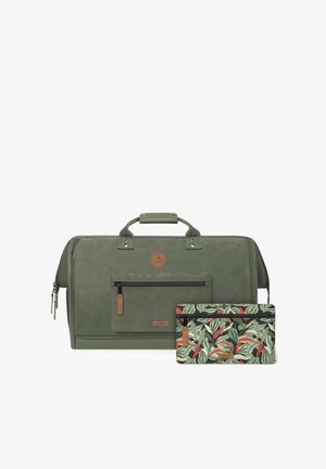Grüne Reisetasche mit strukturierter Oberfläche und einer vorderen Reißverschlusstasche, kombiniert mit einem kleineren gepunkteten Täschchen mit tropischen Blättern.