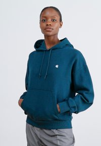 Navy blue hoodie with a front pocket, drawstring hood, and small logo on the chest. Made of soft fabric with a relaxed fit.
