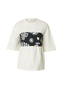 Witte katoenen t-shirt met een zwart patroonpaneel met bloem- en abstracte ontwerpen, korte mouwen en een relaxte pasvorm.